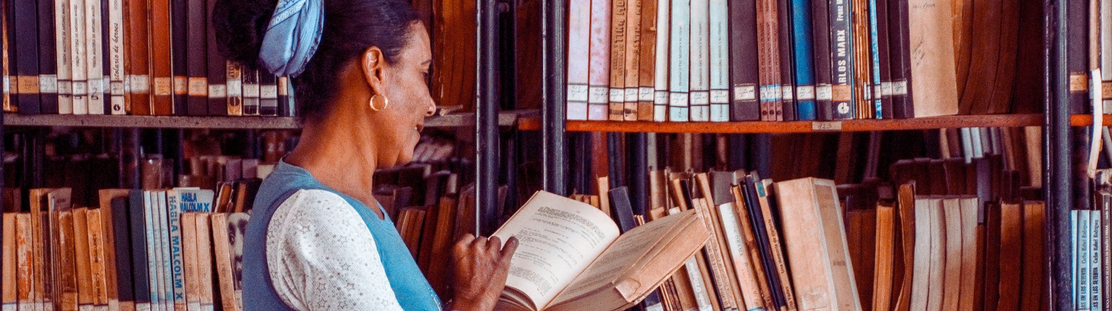 Membre de la communauté universitaire en bibliothèque, illustrant la collégialité universitaire et une gouvernance fondée sur le savoir.